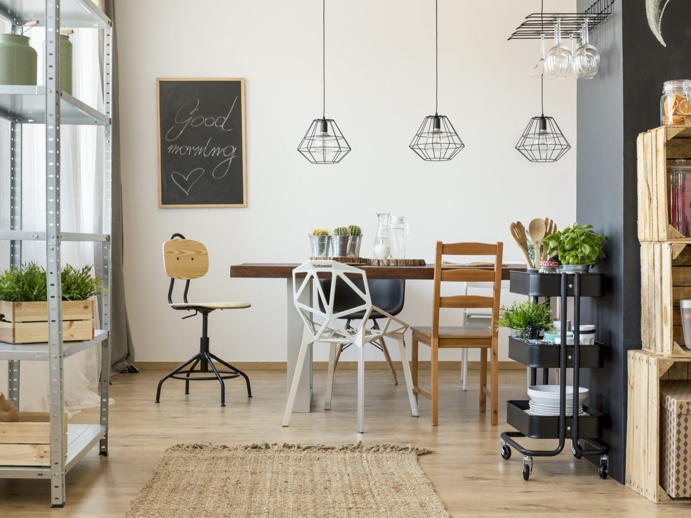 Interior moderno con mesa, sillas y estanterías de madera. Plantas decorativas.